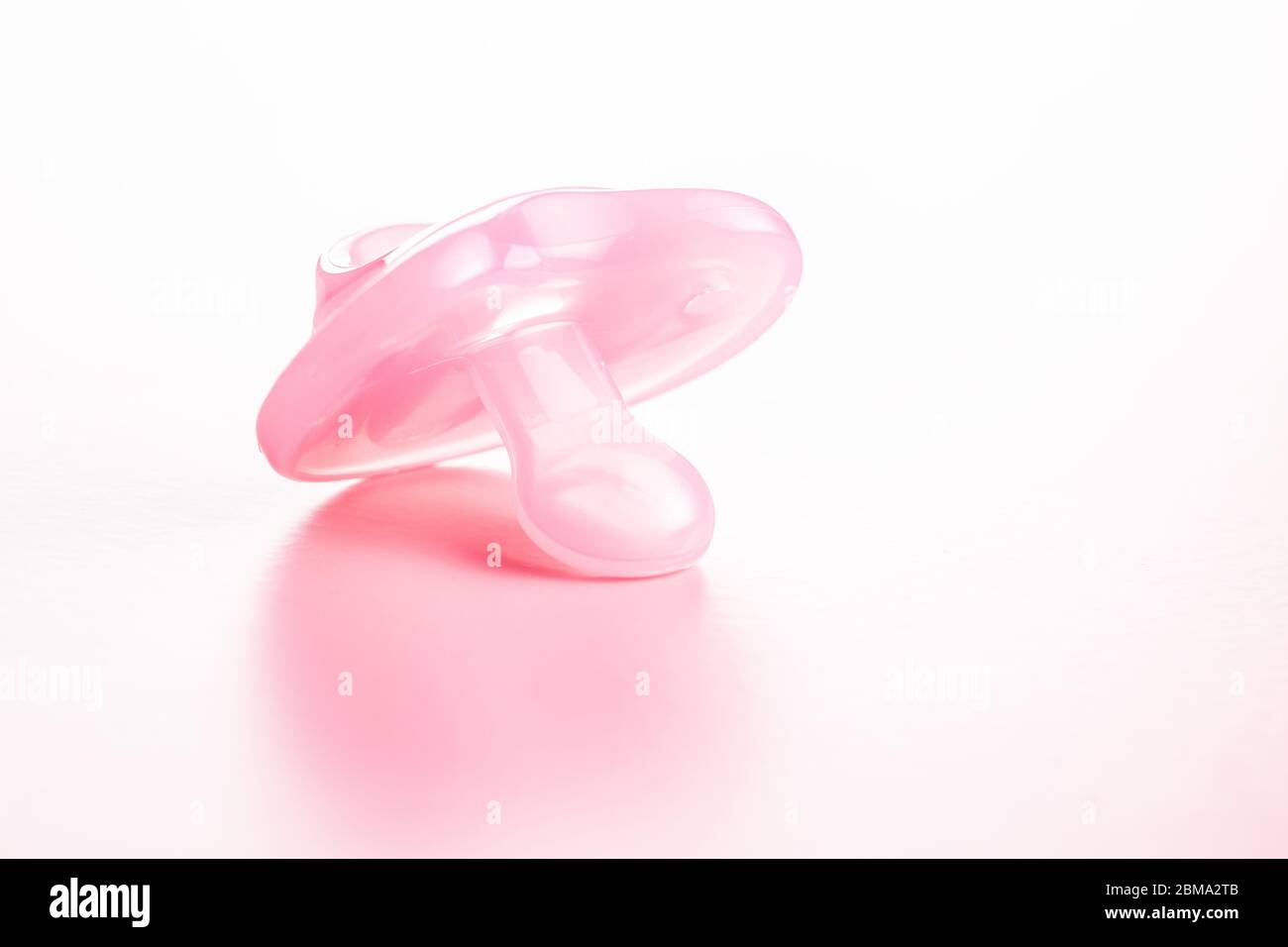 Succhietto in silicone. Succhietto rosa su sfondo rosa. Foto Stock