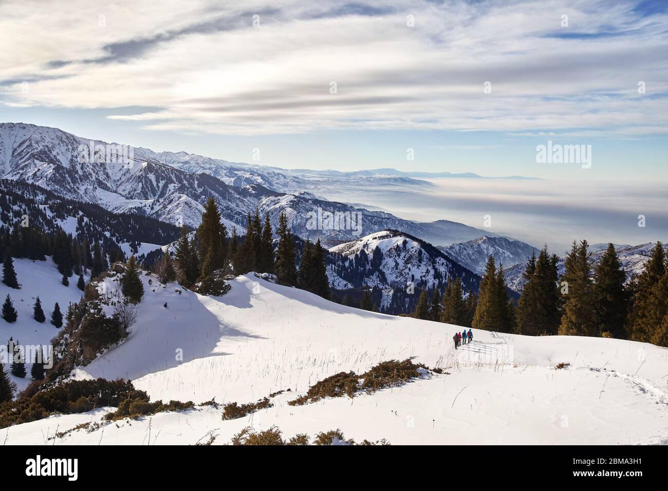 Gruppo di turisti stanno percorrendo a piedi il sentiero di neve al bellissimo sfondo con cielo nuvoloso. Arrampicata Outdoor Concept. Foto Stock
