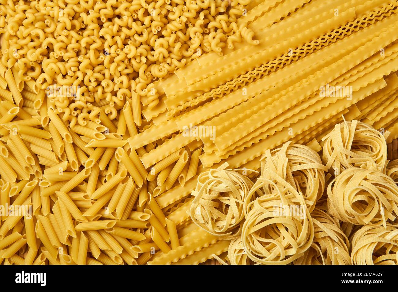 sfondo dorato di pasta secca sparsa di varie varietà Foto Stock
