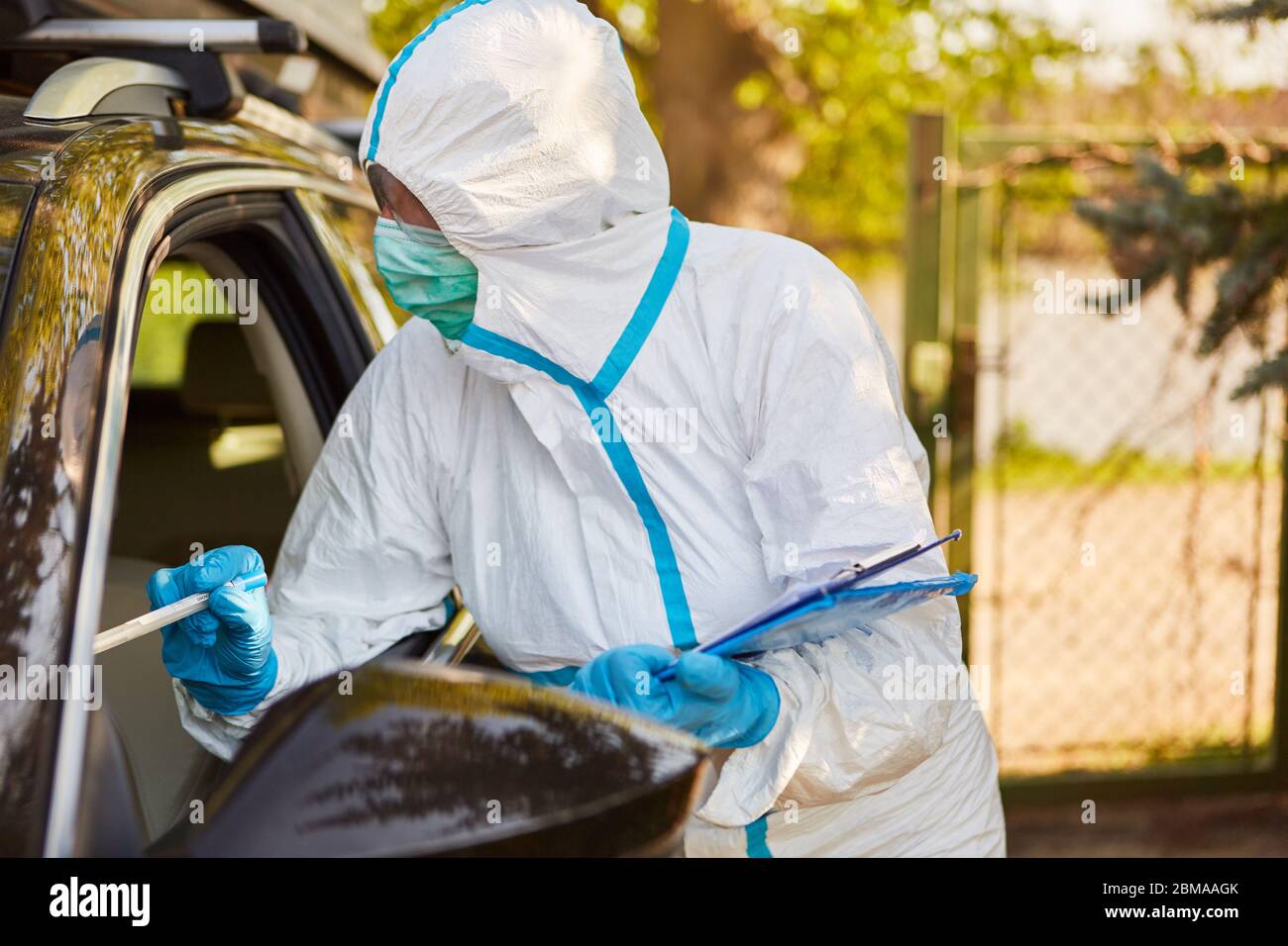Test del coronavirus con tampone alla gola nella stazione di test drive-in mediante scout di contenimento del reparto sanitario Foto Stock
