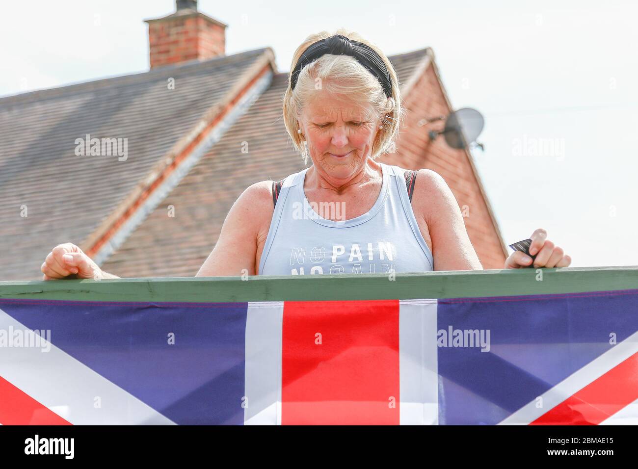 Hunnington, Worcestershire, Regno Unito. 8 maggio 2020. Mentre il Regno Unito celebra il 75° anniversario della Giornata del Ve, una signora inchina la testa per il minuto silenzio in onore nel villaggio di Hunnington, Worcestershire. Credit: Peter Lopeman/Alamy Live News Foto Stock