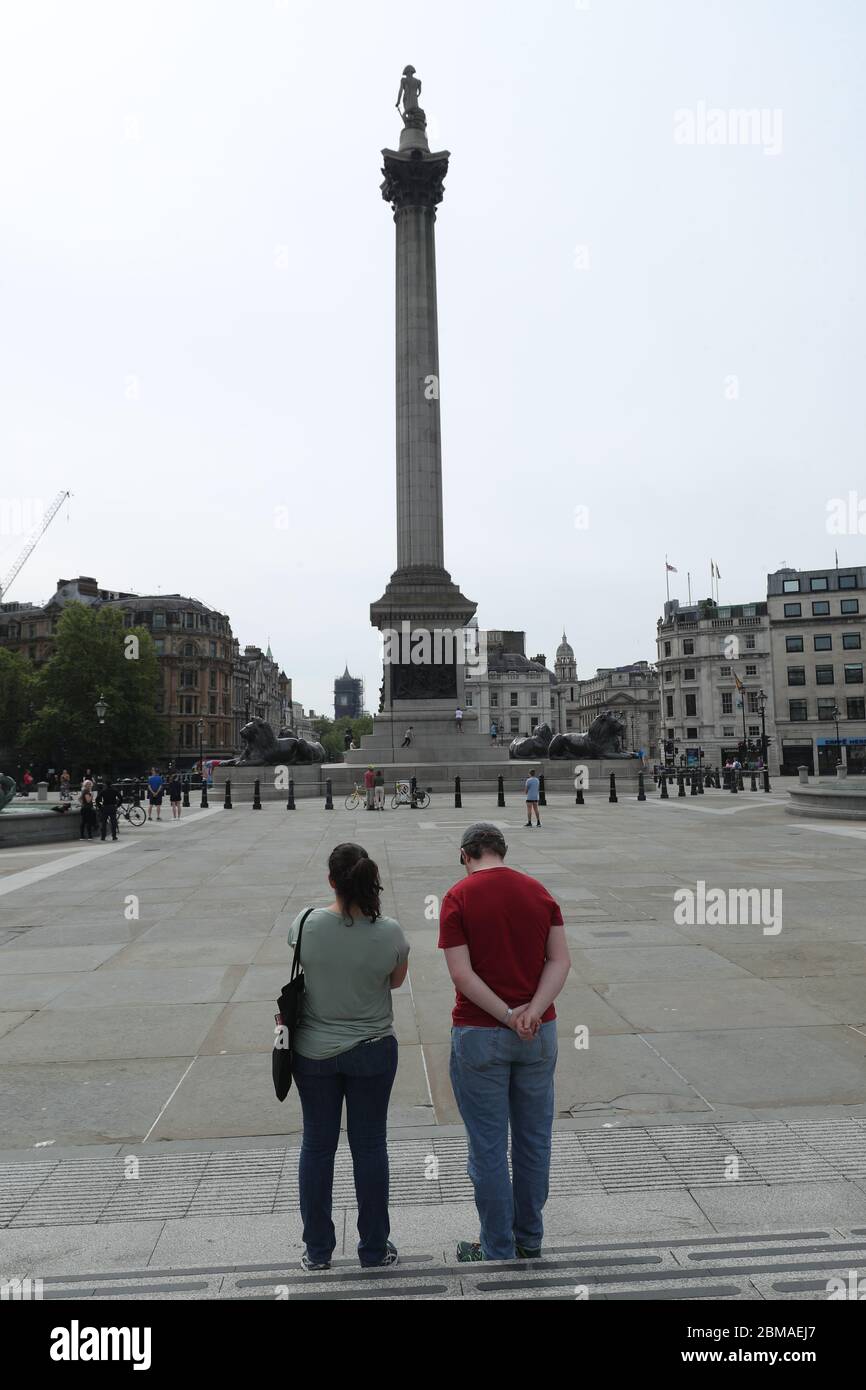 La gente osserva un silenzio di due minuti a Trafalgar Square a Londra, in occasione del 75° anniversario della Giornata del Ve. Foto Stock