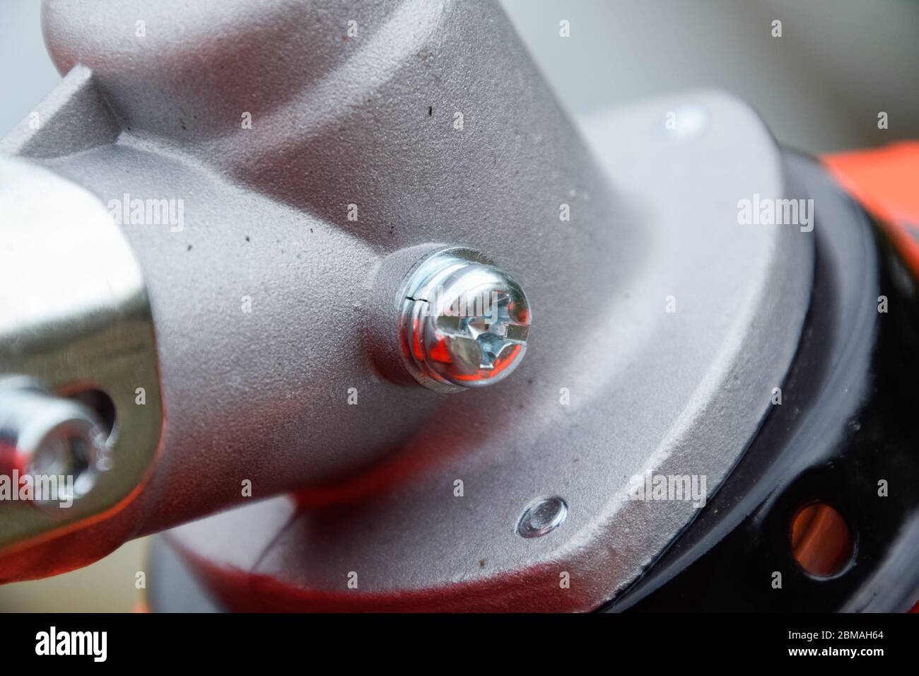 Dispositivi di fissaggio per la costruzione di trimmer a gas. Bulloni e viti sul corpo del trimero. Trimmer Gascosi con una foglia per falciare erba e arbusti. Foto Stock