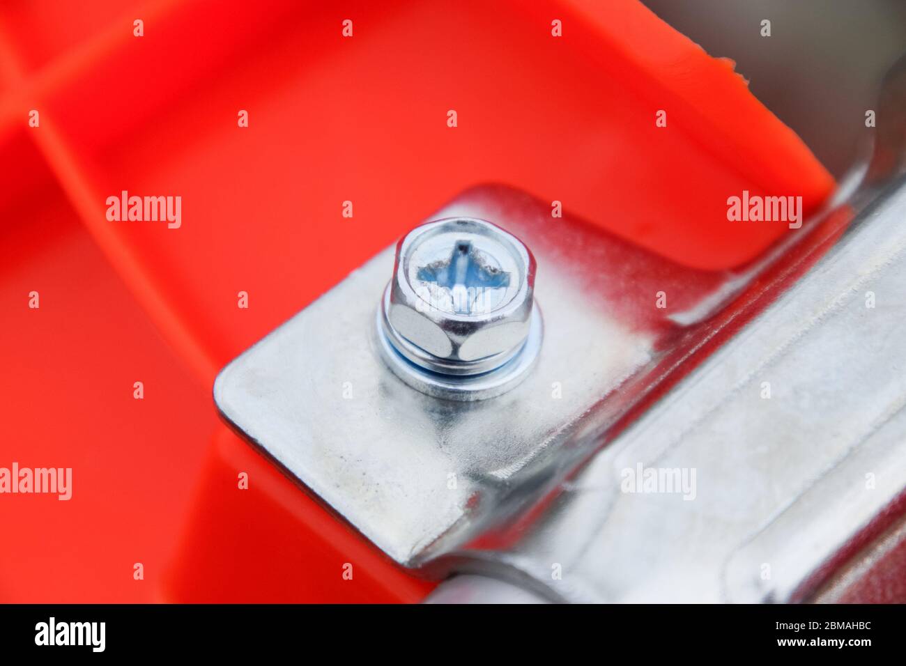 Dispositivi di fissaggio per la costruzione di trimmer a gas. Bulloni e viti sul corpo del trimero. Trimmer Gascosi con una foglia per falciare erba e arbusti. Foto Stock