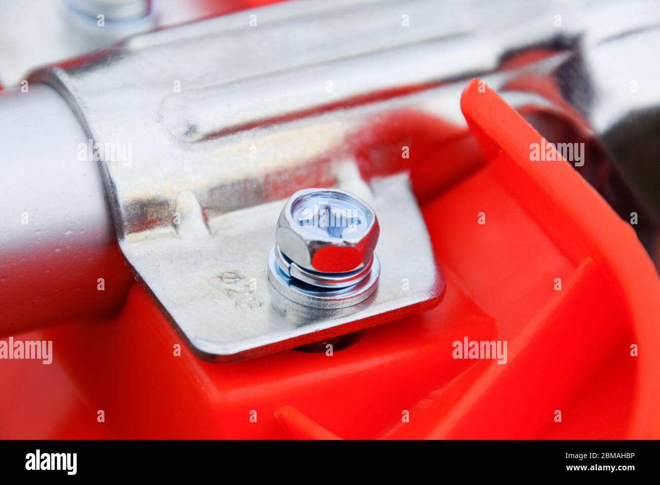 Dispositivi di fissaggio per la costruzione di trimmer a gas. Bulloni e viti sul corpo del trimero. Trimmer Gascosi con una foglia per falciare erba e arbusti. Foto Stock