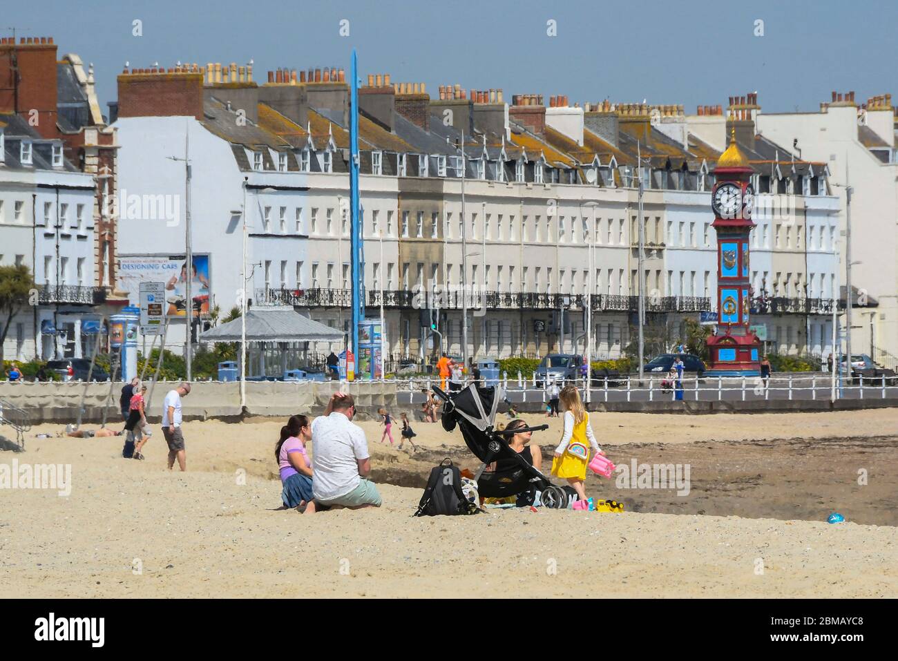 Weymouth, Dorset, Regno Unito. 8 maggio 2020. UK Weather: Una famiglia sulla spiaggia in una giornata di sole caldo presso la località balneare di Weymouth a Dorset, il 75 ° anniversario di VE Day durante il blocco dei coronavirus. Credito immagine: Graham Hunt/Alamy Live News Foto Stock