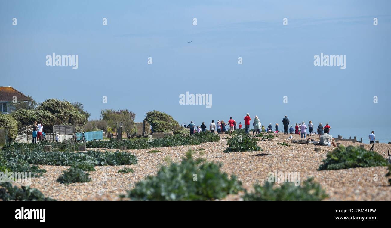 Littlehampton UK 8 maggio 2020 - la gente si raduna sulla spiaggia a Ferring vicino Worthing per guardare il fuoco volare passato in lontananza per commemorare l'anniversario del VE Day durante le restrizioni di blocco del coronavirus COVID-19 pandemic. E '75 anni da quando la vittoria in Europa sui tedeschi è stata annunciata durante la seconda guerra mondiale: Credit Simon Dack / Alamy Live News Foto Stock