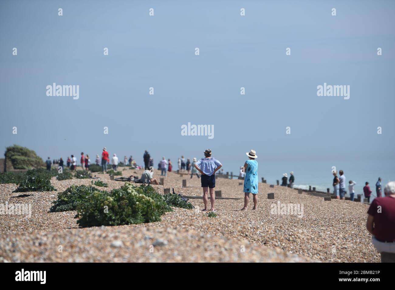 Littlehampton UK 8 maggio 2020 - la gente si raduna sulla spiaggia a Ferring vicino Worthing per guardare il fuoco volare passato in lontananza per commemorare l'anniversario del VE Day durante le restrizioni di blocco del coronavirus COVID-19 pandemic. E '75 anni da quando la vittoria in Europa sui tedeschi è stata annunciata durante la seconda guerra mondiale: Credit Simon Dack / Alamy Live News Foto Stock