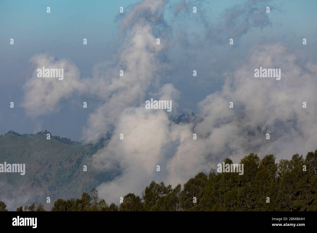 FOGS e basse nuvole al tramonto, ad est, vicino al vulcano bromo, e il massiccio del Tengger, a Giava Est, Indonesia. Foto Stock