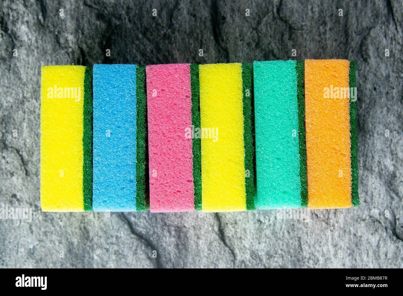 Spugne colorate per la cucina sullo sfondo del tavolo nel colore del marmo bianco. Viste dall'alto, primo piano Foto Stock
