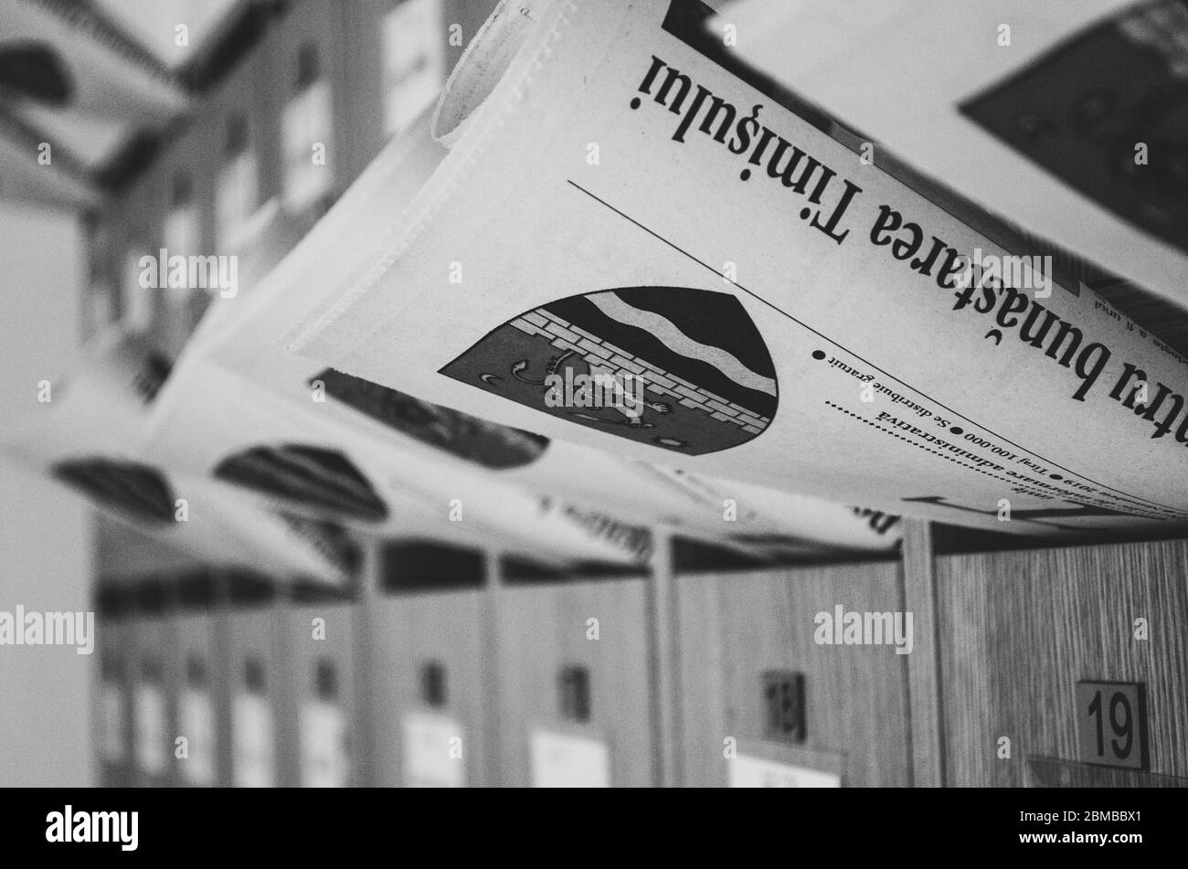 Alcuni giornali in attesa nelle rispettive caselle postali, composizione in bianco e nero Foto Stock