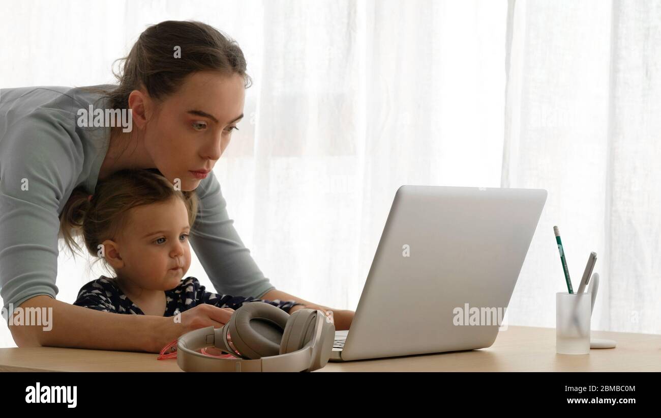 Madre e bambina che usano il laptop a casa Foto Stock