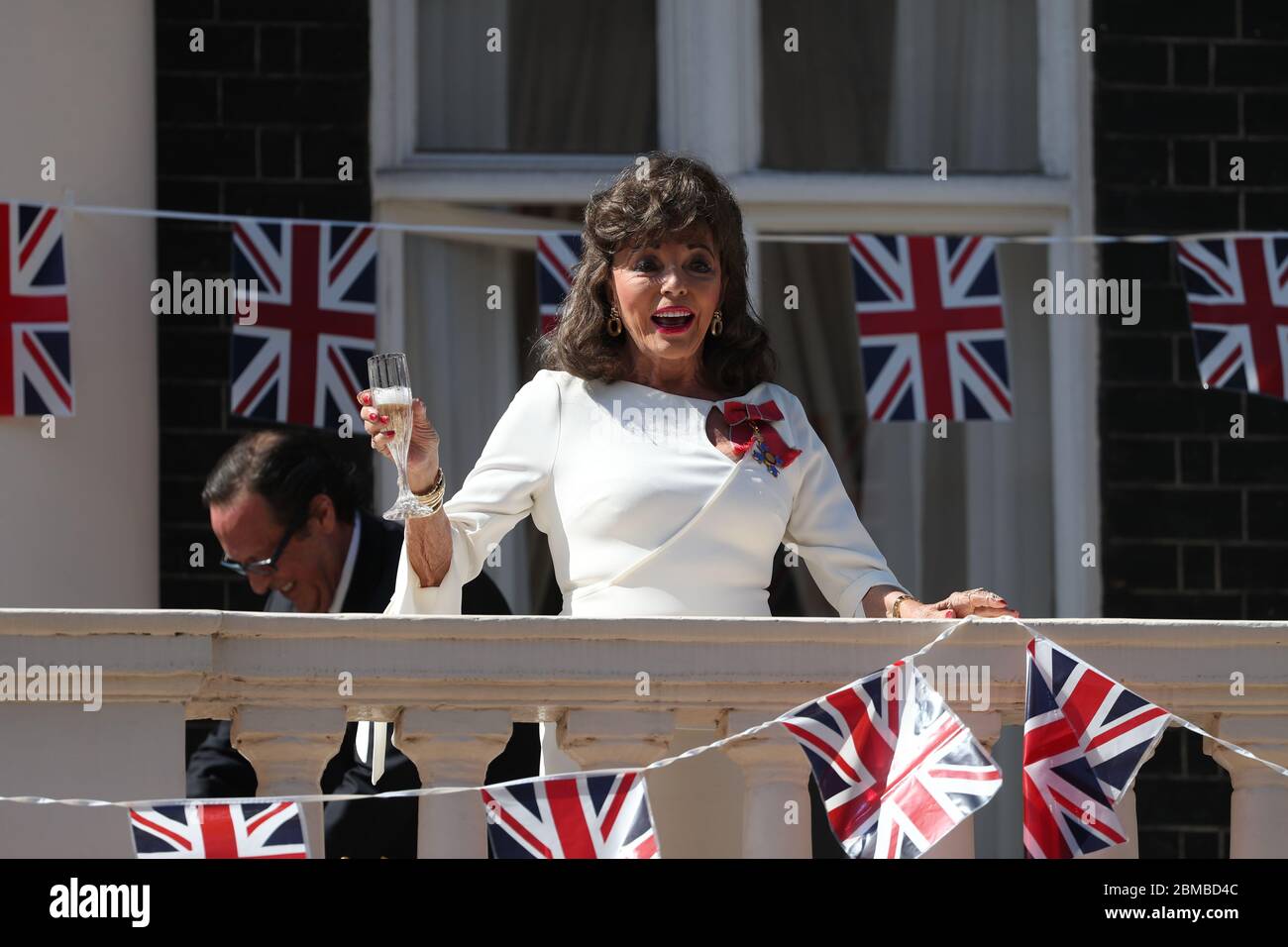 Dame Joan Collins conduce un 'Nation's Toast' per conto delle donne della nazione dal balcone del suo appartamento a Londra. Il brindisi è in memoria di tutti coloro che hanno sacrificato così tanto per il loro paese, nel 75° anniversario della Giornata del Ve. Foto Stock