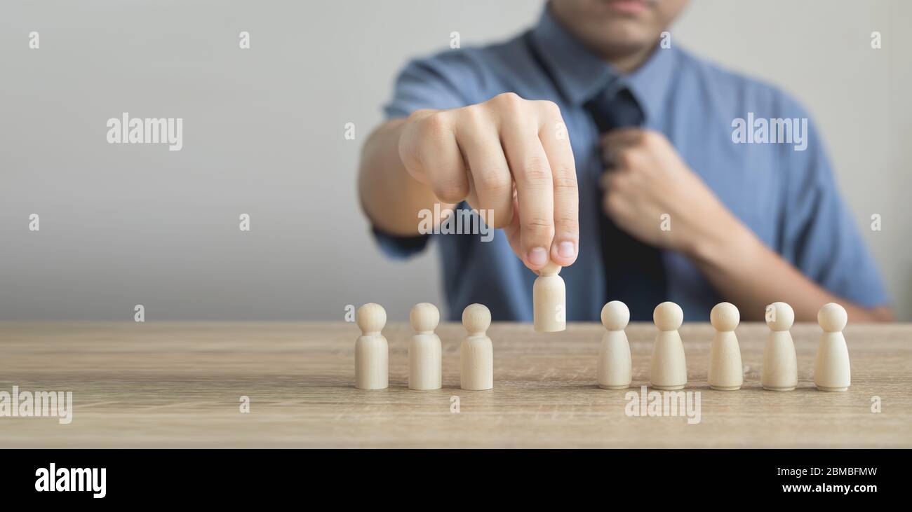 Il proprietario sta raccogliendo o seleziona la figura di legno sul roe di legno nei concetti di gestione di risorse umane Teamwork.Success Leadership, progresso di affari e compe Foto Stock