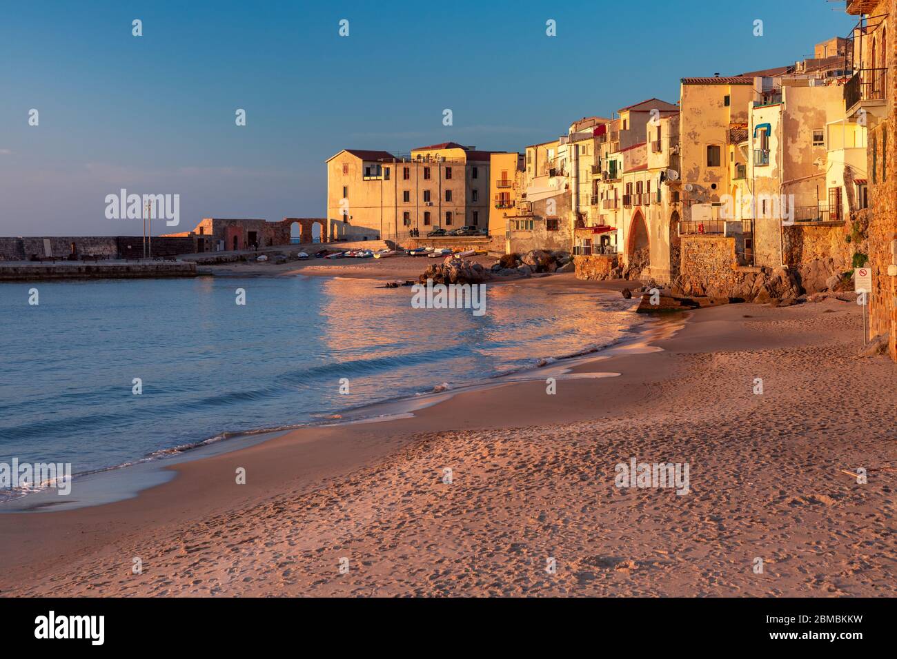 Spiaggia di sabbia vuota nel centro storico della città costiera Cefalu al tramonto, Sicilia, Italia Foto Stock