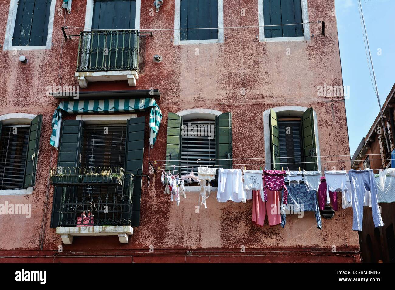 Lavanderia asciugandosi, appesa su una linea di vestiti stesa tra due edifici a Murano, Italia Foto Stock