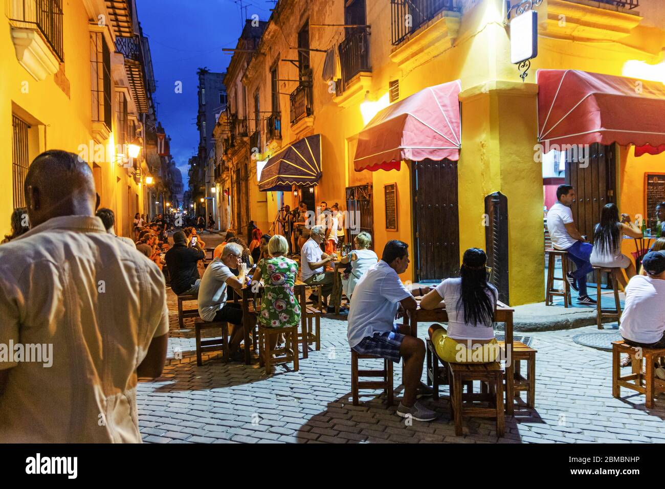 Havana, Cuba - 25 luglio 2018: Turisti e locali mangiano fuori un caffè di notte con musica suonata in un cortile a Cuba Havana. Foto Stock