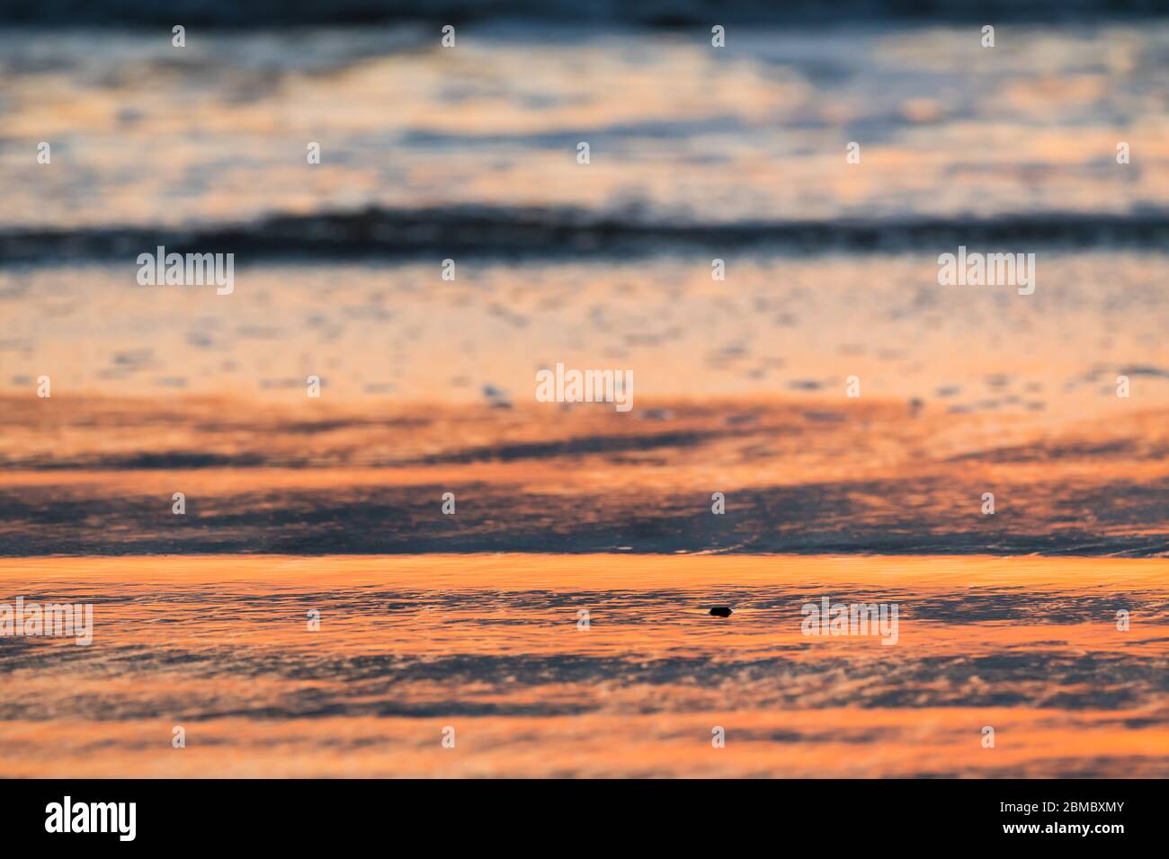 tramonto sulla riva del mare, le onde dolci rotolano sulla spiaggia di sabbia con sfondo sfocato uso come astratta natura, sfondo, carta da parati Foto Stock