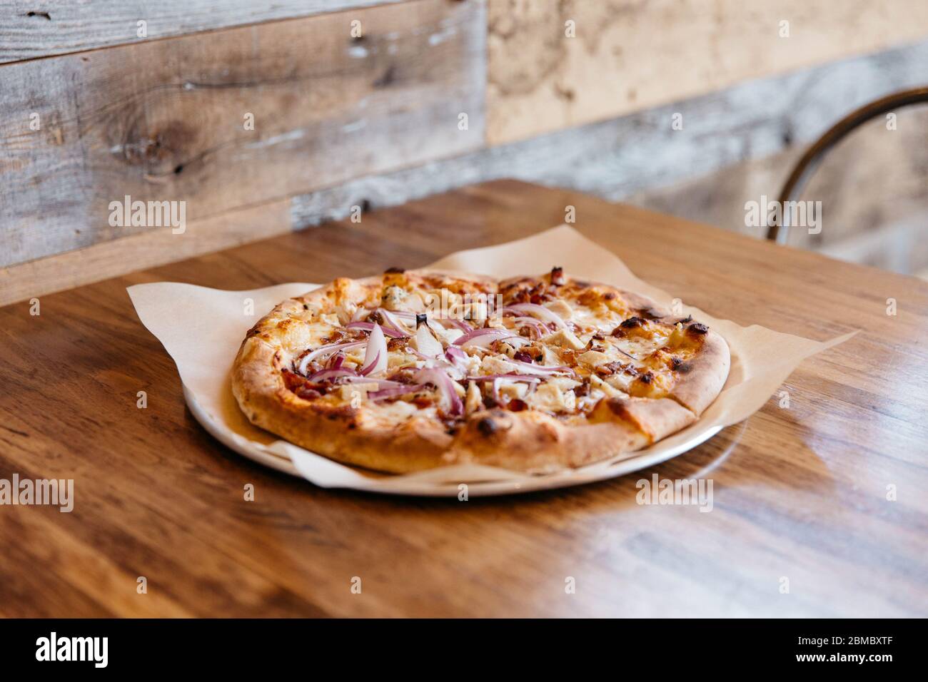 Pizza fatta a mano su tavola di legno Foto Stock