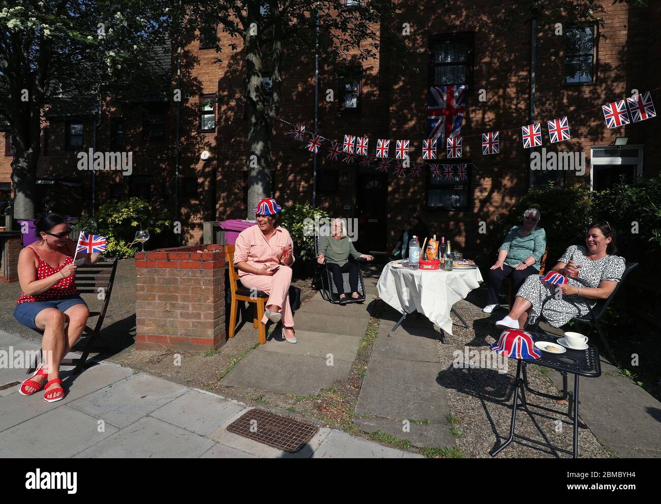 I residenti di Saunders Ness Road nell'Isola dei cani, Londra est, lanciano una festa di strada con le distanze sociali per celebrare il 75° anniversario del VE Day. Foto Stock
