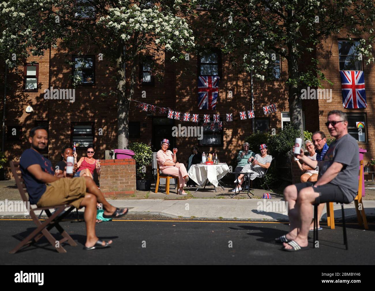 I residenti di Saunders Ness Road nell'Isola dei cani, Londra est, lanciano una festa di strada con le distanze sociali per celebrare il 75° anniversario del VE Day. Foto Stock