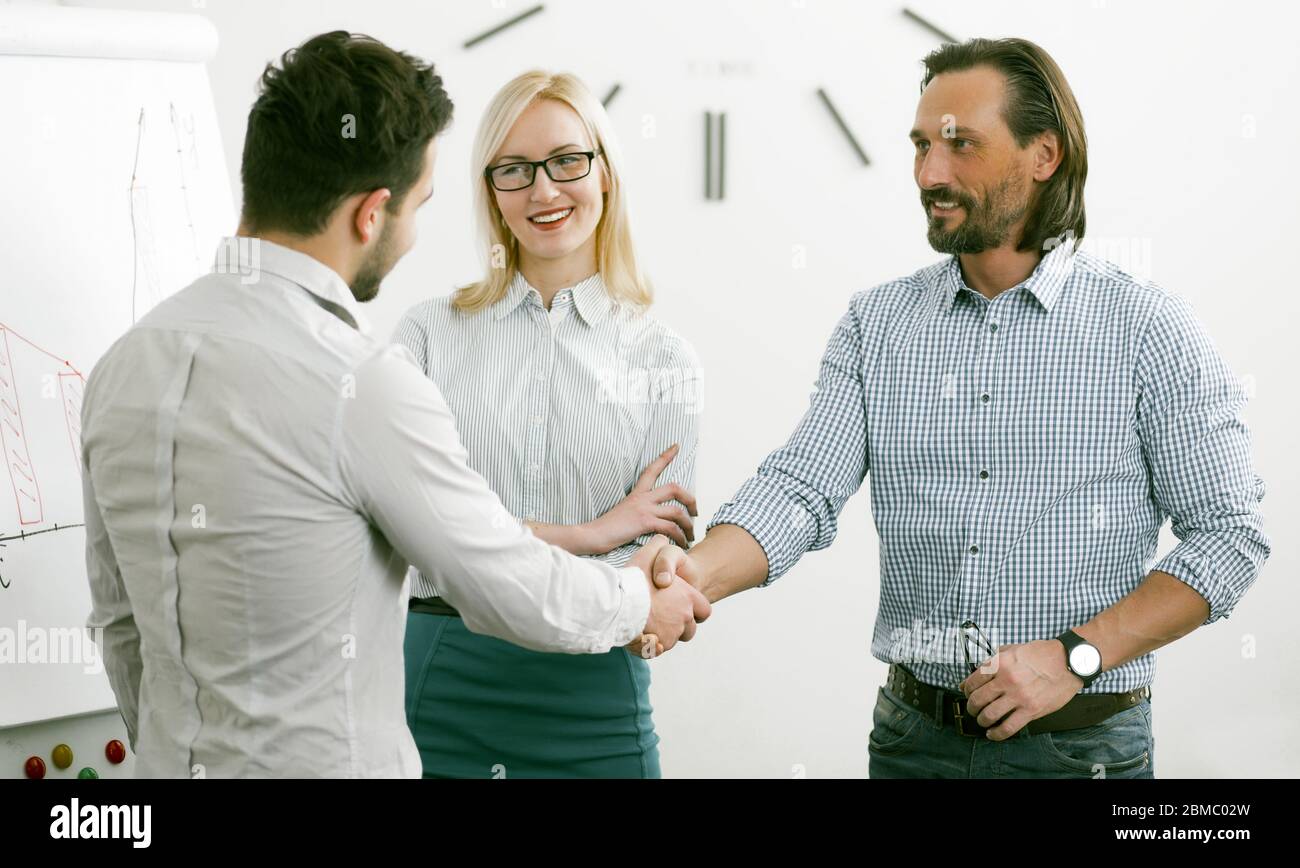 Stretta di mano di affari di uomini felici. Stretta di mano di uomini d'affari che cercano amico nell'occhio. Due uomini in formalwear scuotendo le mani in accordo al business Foto Stock