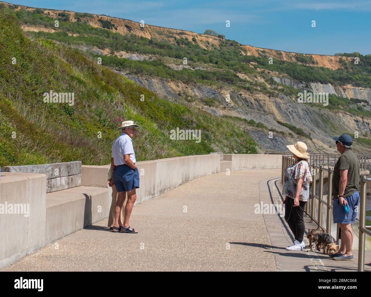 Lyme Regis Dorset, Regno Unito. 8 maggio 2020. UK Weather: Un caldo e soleggiato pomeriggio di vacanza in banca a Lyme Regis, West Dorset. Gli amici si fermano a chiacchierare mantenendo le distanze sociali. Credit: Celia McMahon/Alamy Live News. Foto Stock