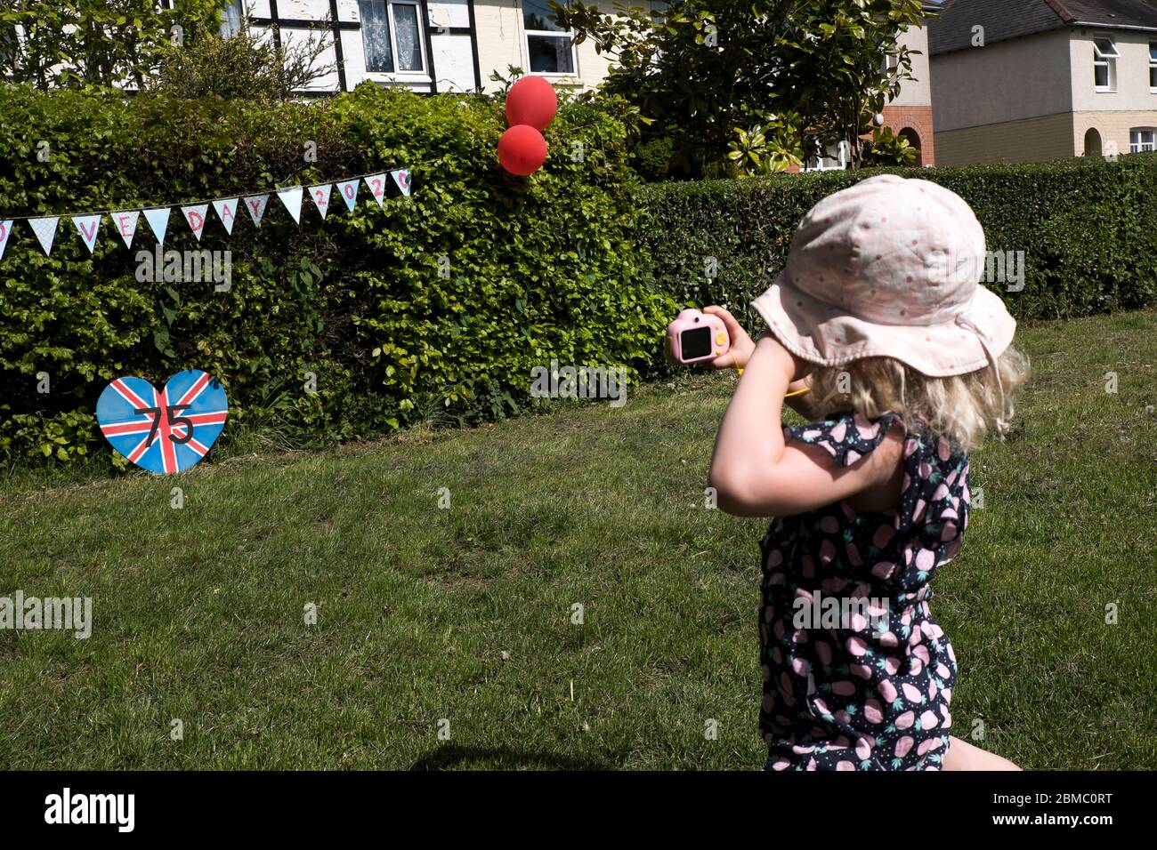 Una giovane ragazza prende una fotografia di un'esposizione del VE Day a Bugbrooke, Northamptonshire Foto Stock