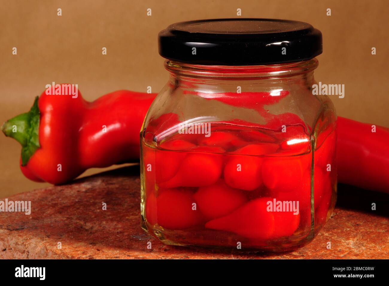 contenitore in vetro con peperoni caldi da vicino Foto Stock