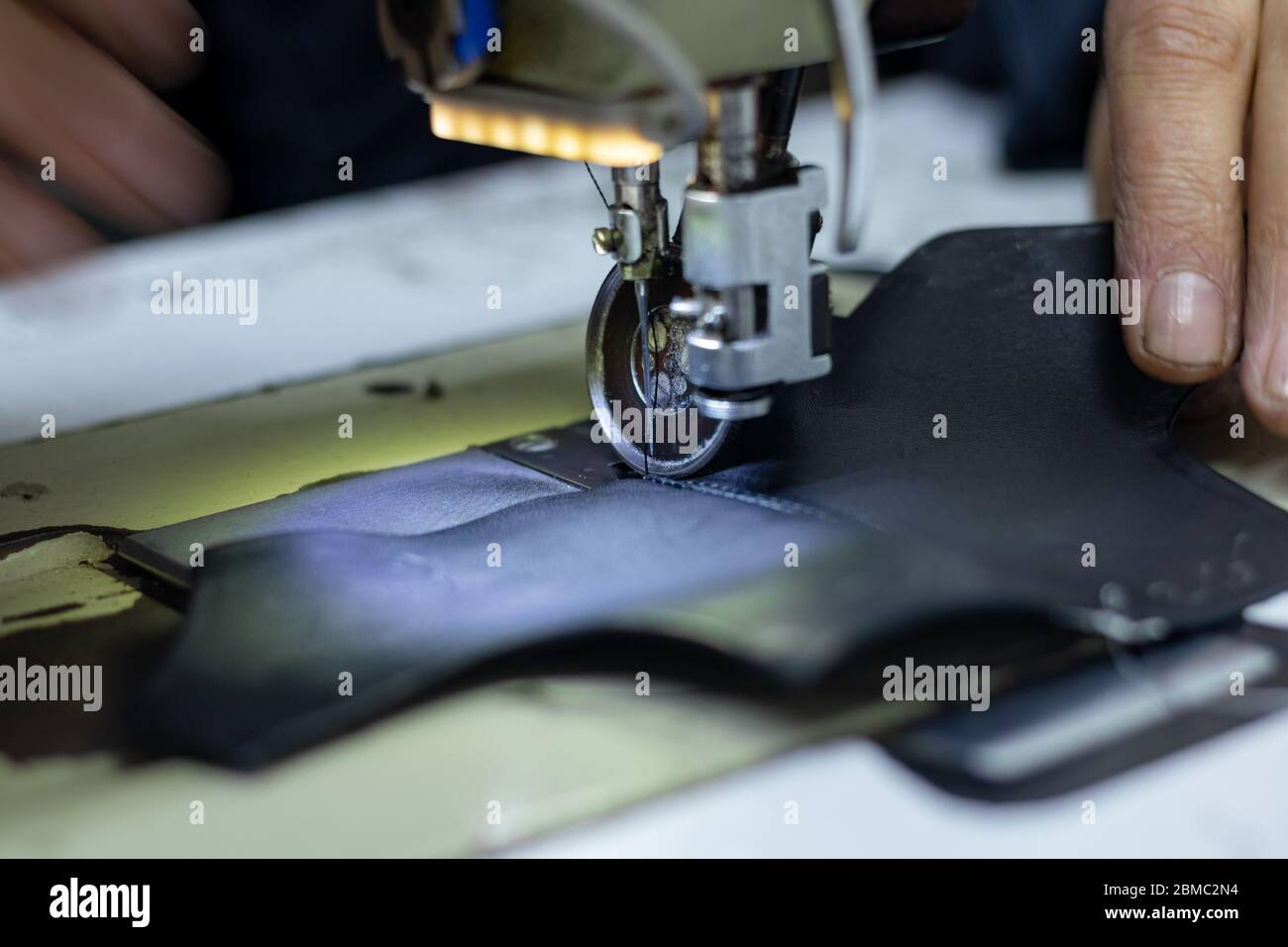 Uomo cucito una pelle su macchina da cucire per la realizzazione di calzature Foto Stock