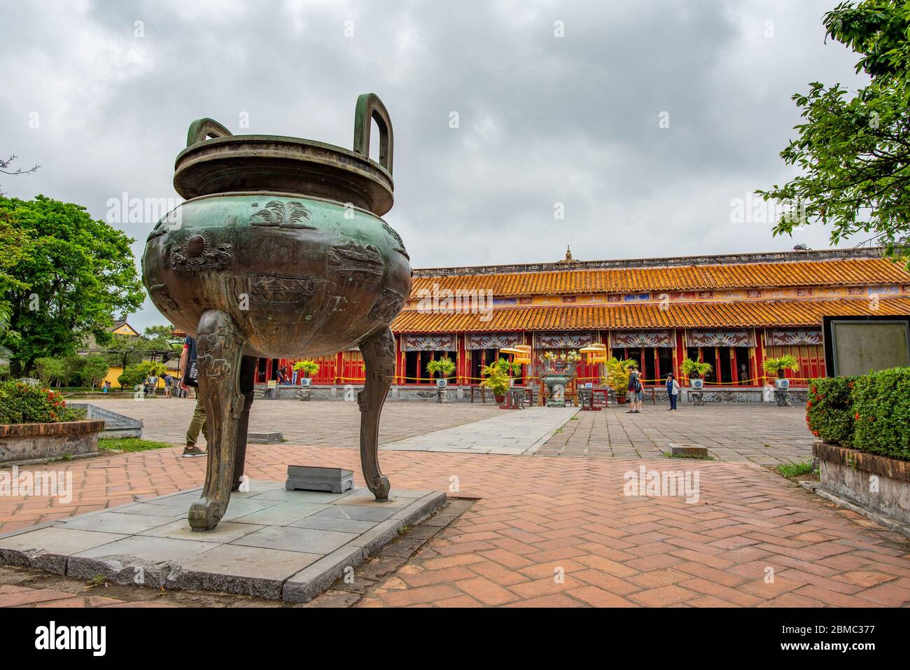 Hue, Vietnam - 15 aprile 2018: Una delle famose urne (caldron) della cittadella di Hue con pochissimi turisti e un cielo coperto Foto Stock