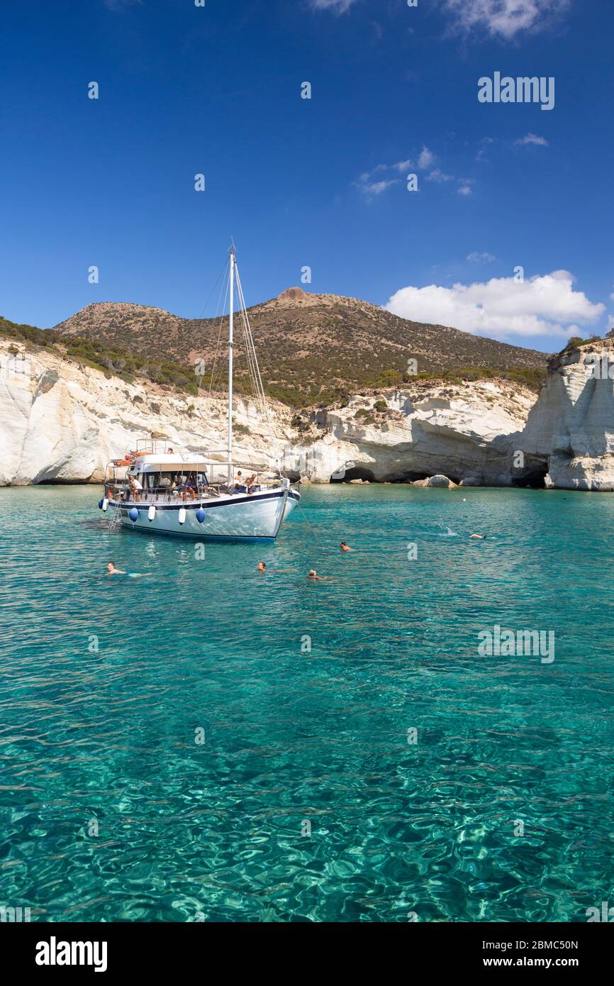 Una barca e persone che nuotano a Kleftiko, Milos, Cicladi, Grecia Foto Stock