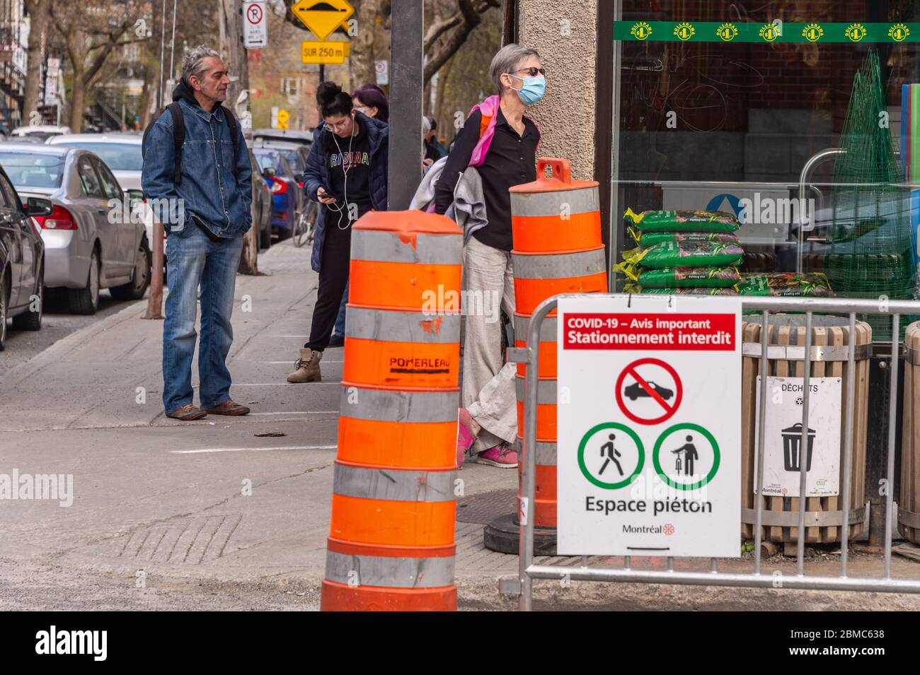 Montreal, CA - 8 maggio 2020 : clienti in una linea fuori dal negozio. Alcune di esse indossano maschere di protezione Covid-19. Foto Stock