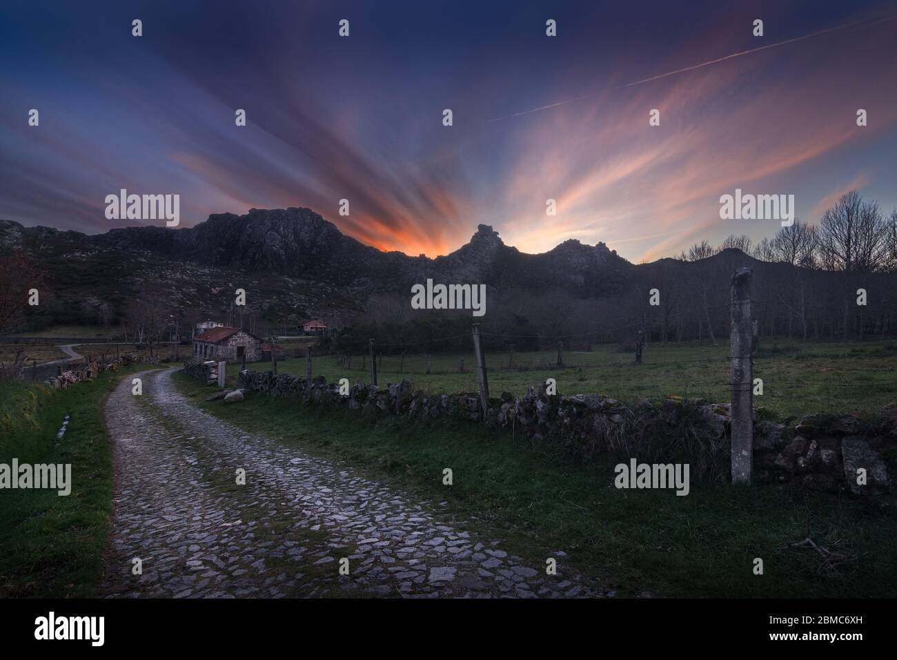 Una tipica strada in pietra portoghese che è usata per raggiungere i campi di mucche e la piccola città nel mezzo di questa valle di montagna nel parco di Peneda Geres Foto Stock Una tipica strada in pietra portoghese che è usata per raggiungere i campi di mucche e la piccola città nel mezzo di questa valle di montagna nel parco di Peneda Geres Foto Stock