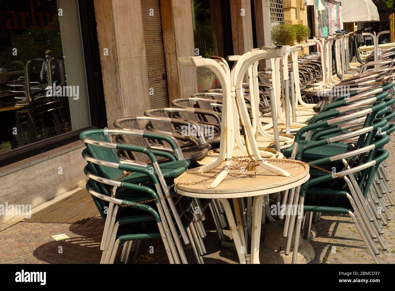 Tavoli e sedie di un ristorante impilati e incatenati insieme. Ultimi giorni di soggiorno a Merano, Italia. Fase 2 di COVID-19. Foto Stock