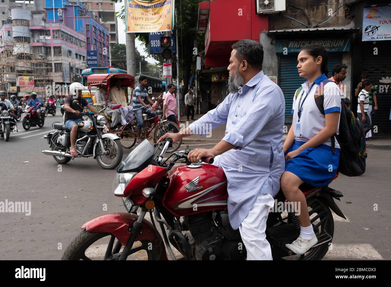 Padre e figlia su una moto a Kolkata, India Foto Stock