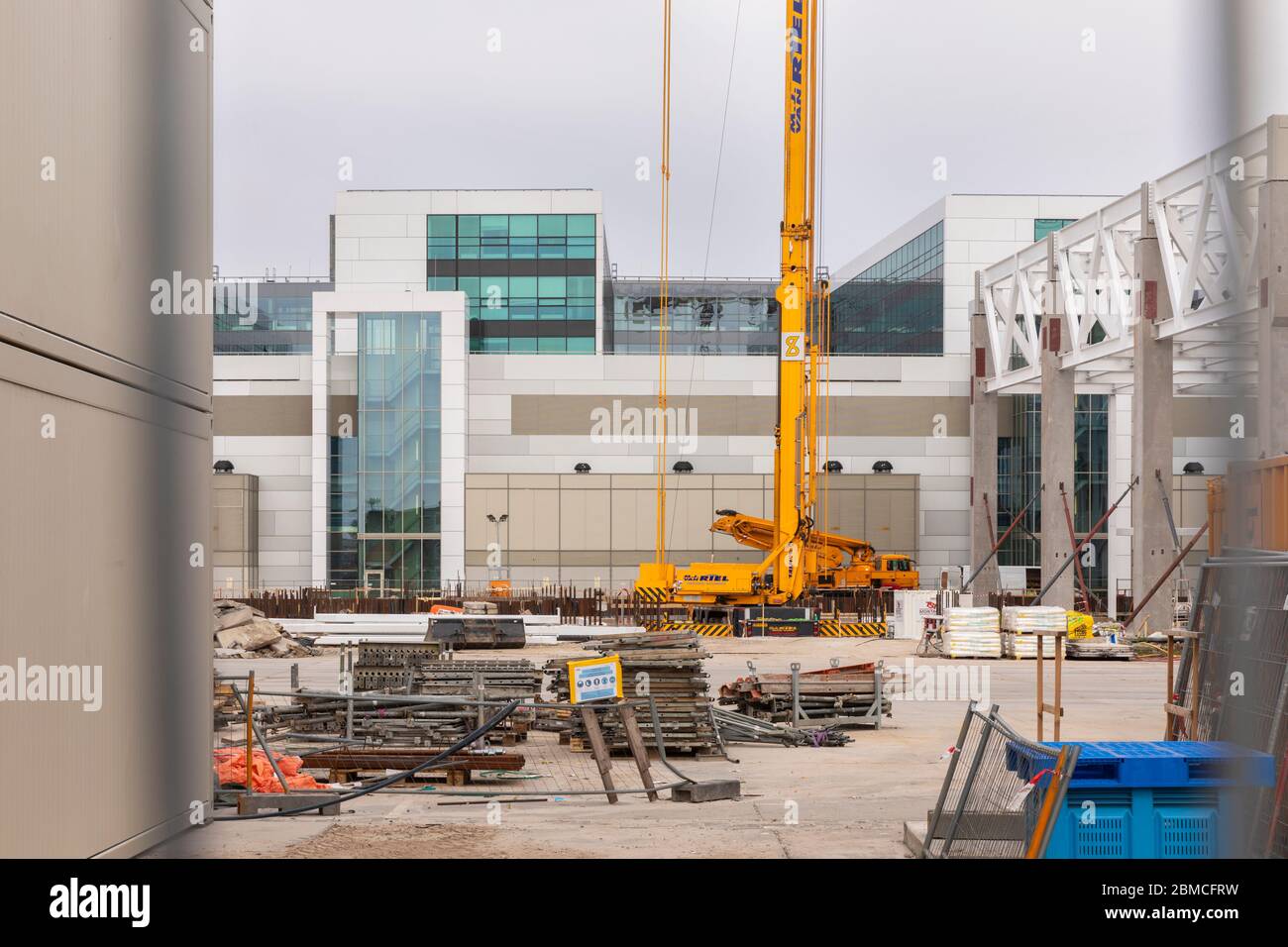 Veldhoven, Paesi Bassi, 8 maggio 2020. Un cantiere con i nuovi edifici ASML in fase di sviluppo. Una grande gru gialla e materiale da costruzione Foto Stock