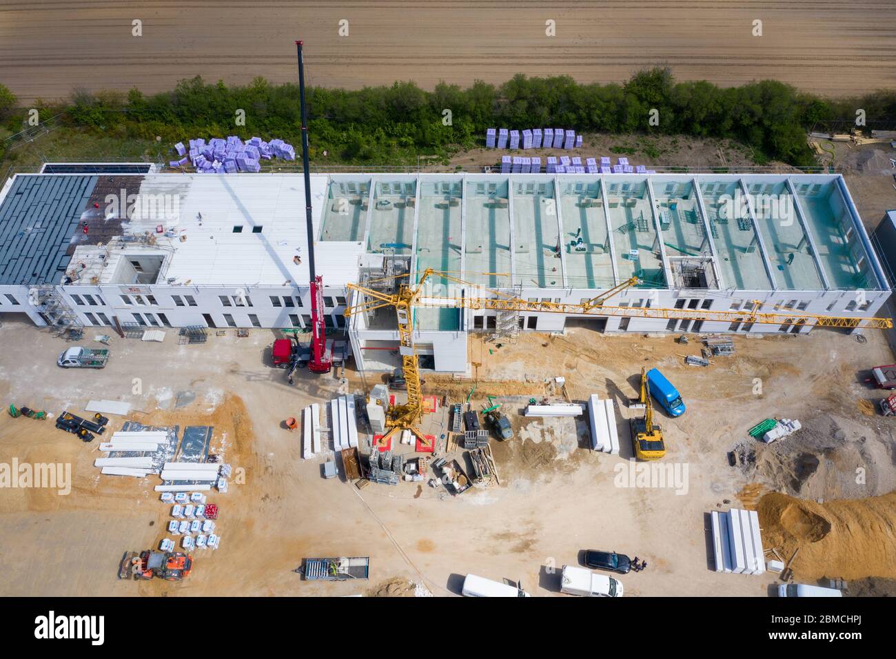 una fotografia a droni di un grande cantiere su cui si sta costruendo un grande locale industriale Foto Stock