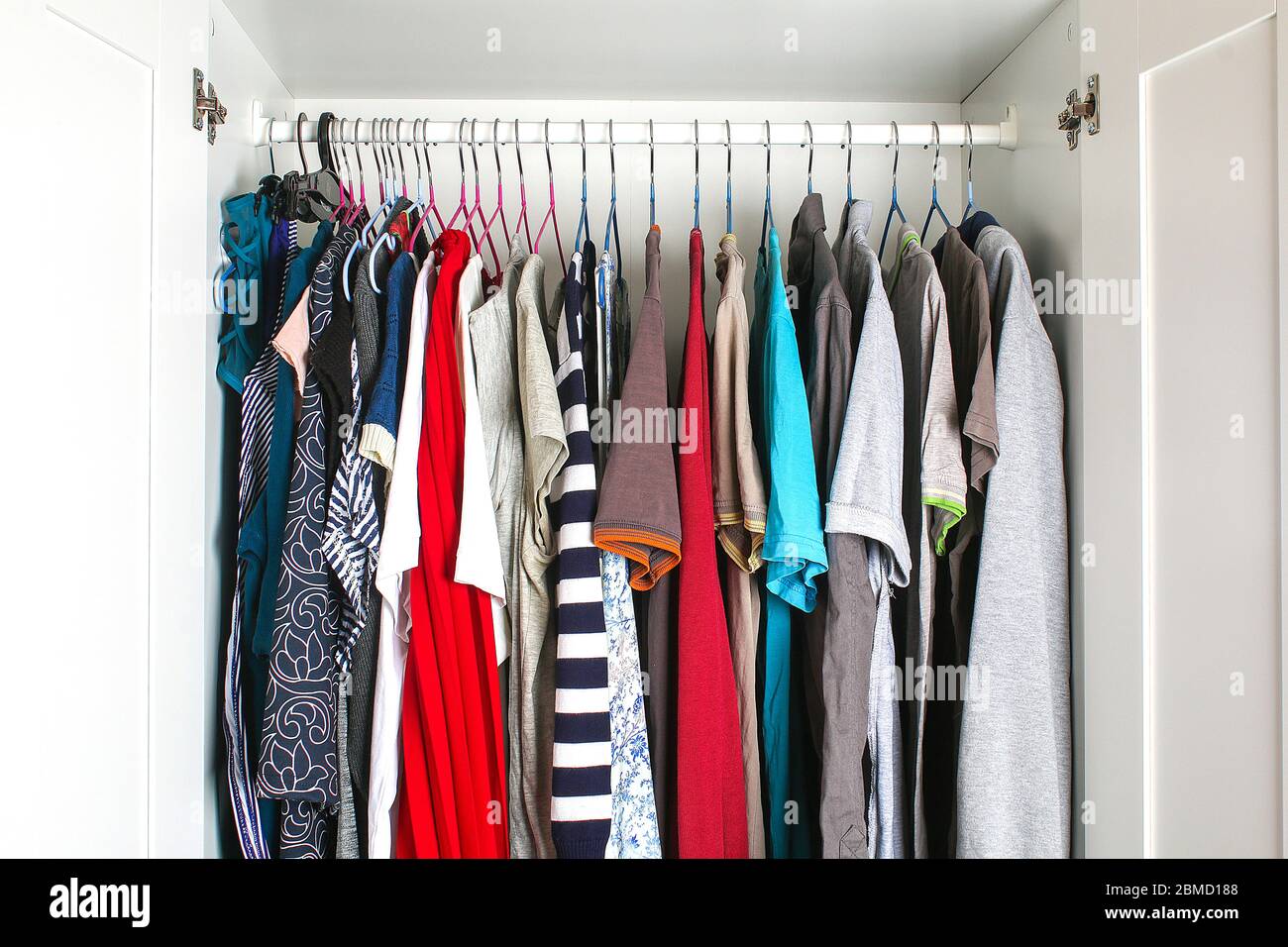 Abbigliamento da uomo e da donna su staffe in silicone nell'armadio. Le stesse spalle. Organizzazione di storage. Ordine e pulizia. Quarantena, se Foto Stock