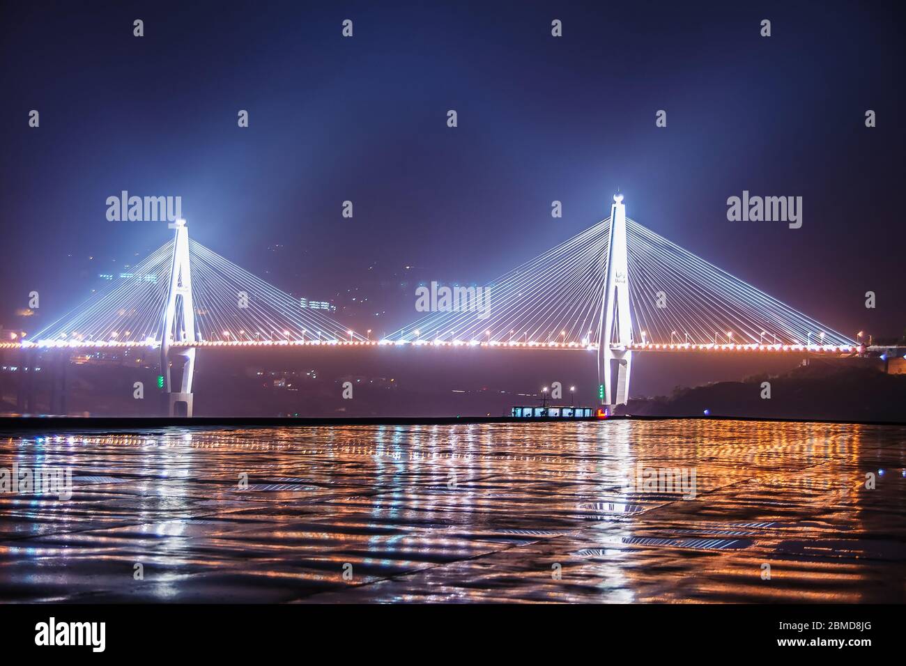 Xinling, Cina - 6 maggio 2010: Gola di Xiling sul fiume Yangtze. Foto notturna del ponte Badong con i suoi 2 piloni e completamente illuminato in 3 colori, Refl Foto Stock