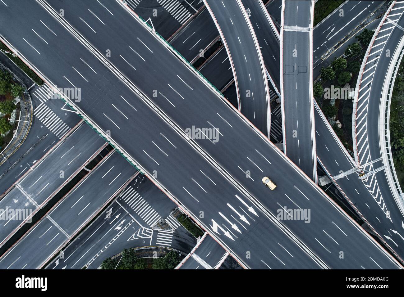 Vista aerea di una singola auto sta guidando su autostrada vuota e cavalcavia in città Foto Stock