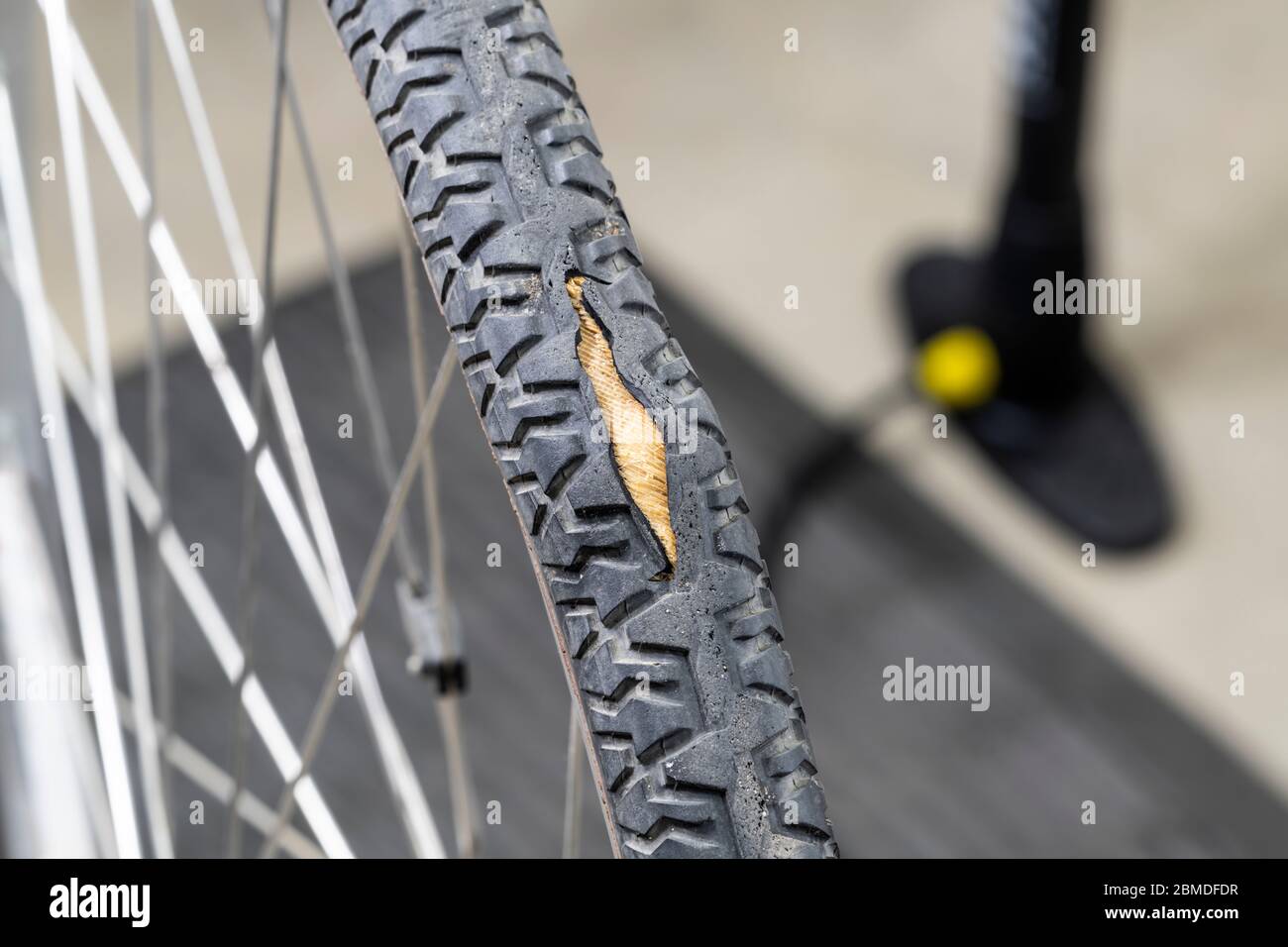 Od pneumatico della bicicletta usurato con cavo che si presenta attraverso il battistrada in gomma spaccata. Foto Stock