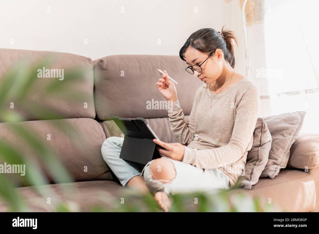 Giovane artista digitale professionale che lavora da casa. Ragazza freelance grafica asiatica che pensa e cerca ispirazione lavoro da casa Foto Stock