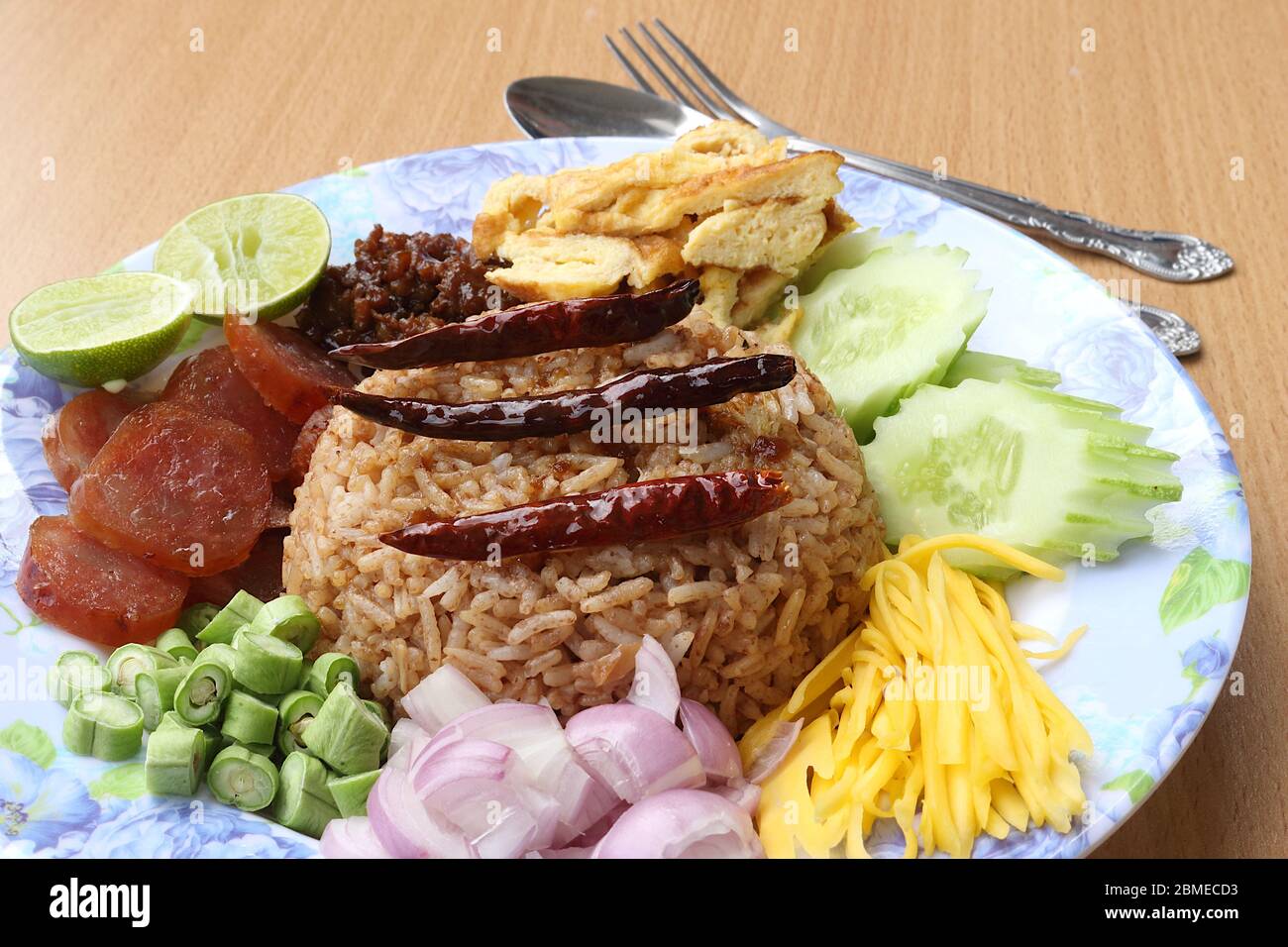 Vista dall'alto. Riso misto con pasta di gamberi composta da maiale dolce, salsiccia cinese, uova fritte, fette di cetriolo, mango agrodolce, scalogno, fagiolo lungo, roa Foto Stock