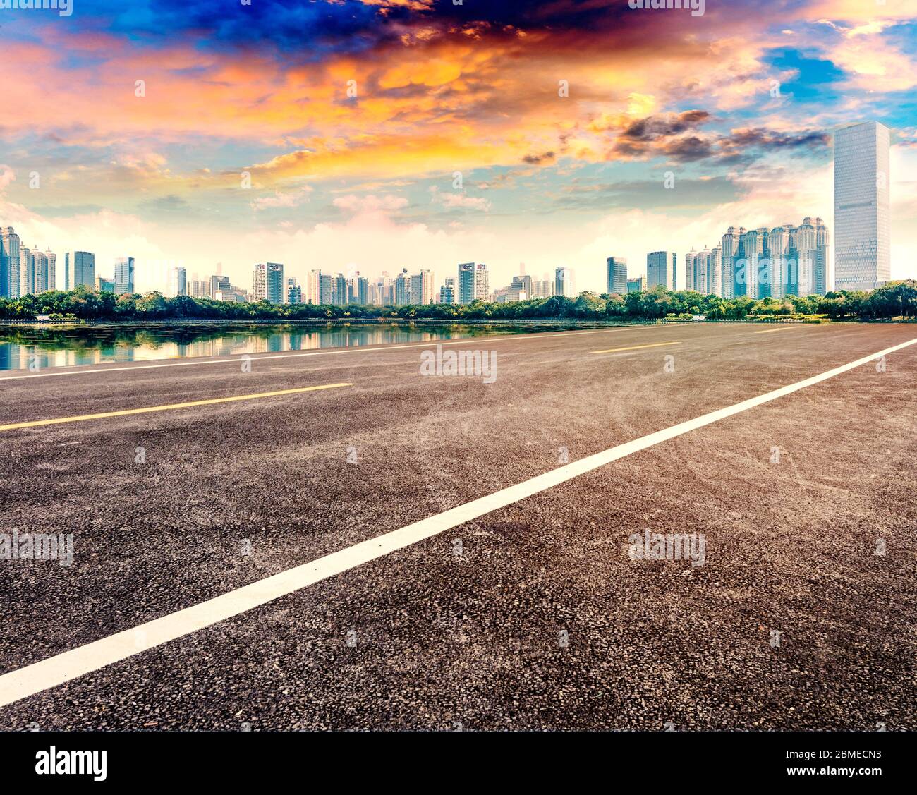 Tramonto paesaggio di strada asfaltata vuota e edifici della città. Foto Stock