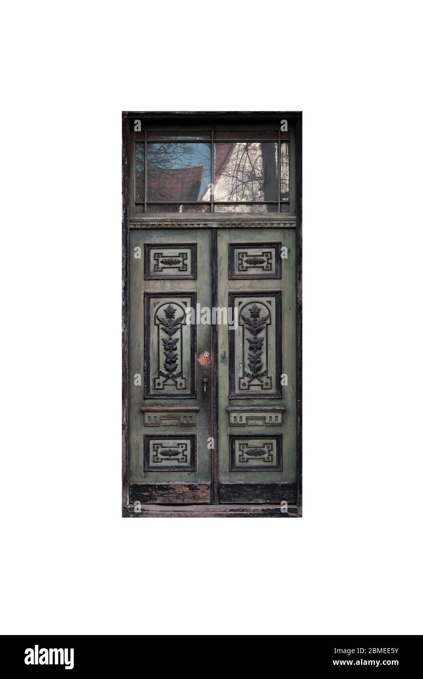 Porta di legno verde scuro con decor nella facciata dell'edificio vecchio isolata su sfondo bianco Foto Stock