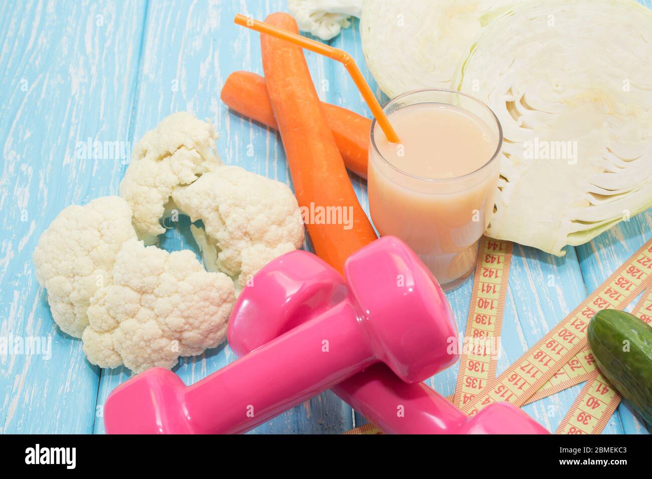 Concetto di fitness con manubri e cibo sano. Vegetarianismo nello sport. Foto Stock