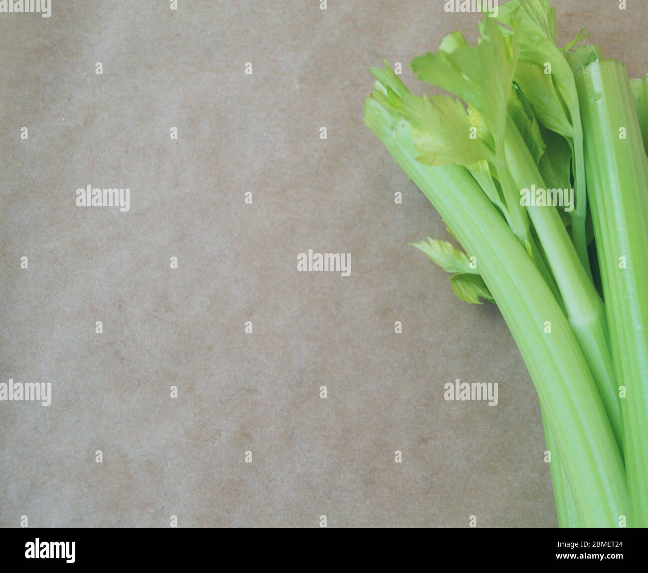 Gambi di sedano fresco verde con giardino sullo sfondo di carta marrone pergamena vegetale cibo sano prodotto organico isolato Foto Stock