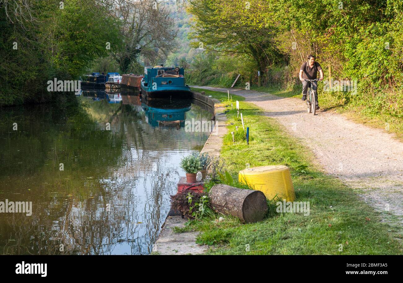 Bagno, Inghilterra - 19 Aprile 2011: Un ciclista sulle navi in transito sul Kennet & Avon Canal alzaia vicino a Bath in Somerset. Foto Stock