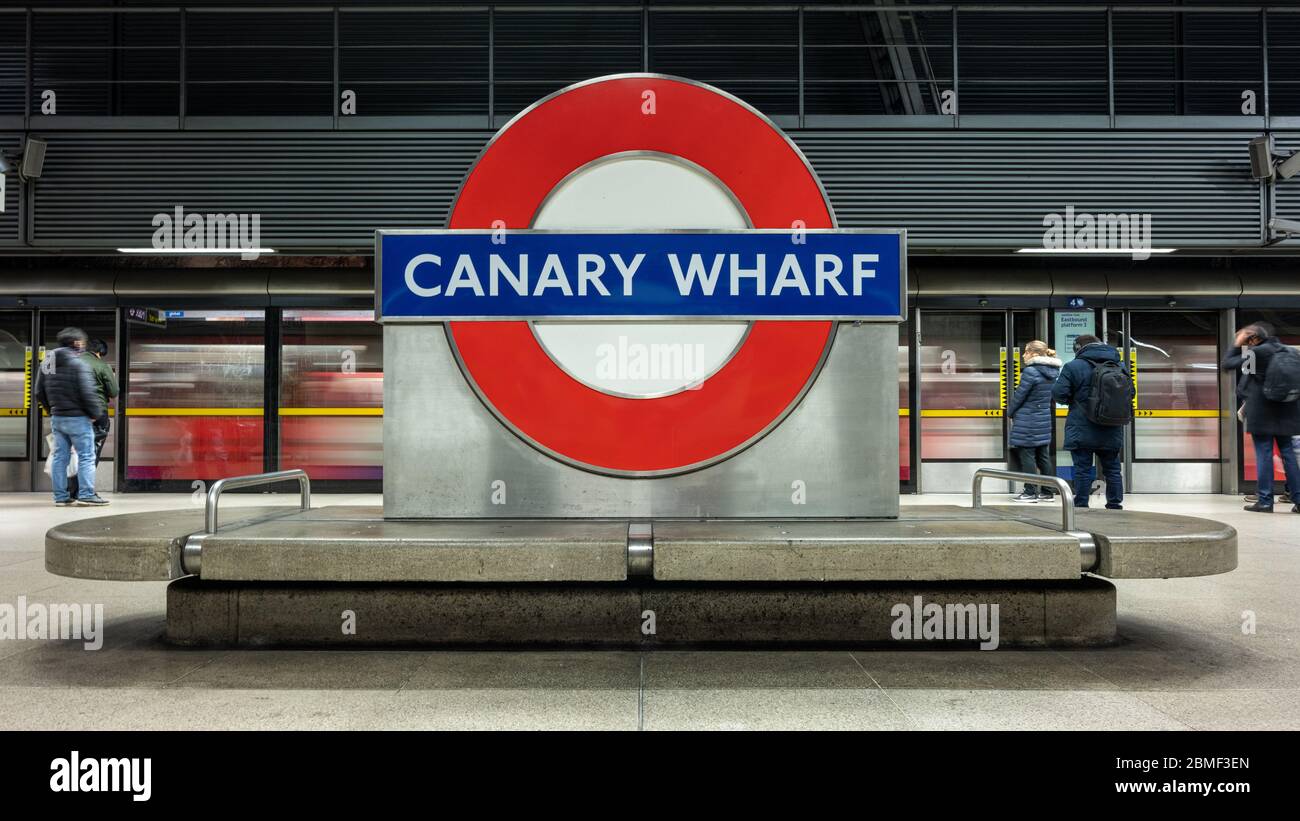 Londra, Inghilterra, Regno Unito - 10 marzo 2020: I pendolari si fermano alle porte della piattaforma, mentre un treno Jubilee Line arriva alla stazione della metropolitana di Canary Wharf. Foto Stock